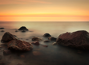 Roter Sonnenuntergang mit Wassernebel an der Ostsee
