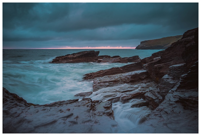 Blick auf die Felsen im Ozean bei Trebarwith Beach zum Sonnenuntergang