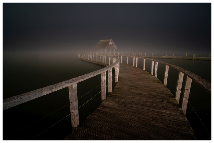 Blick auf den Steg am Hemmelsdorfer See in einer nebligen Nacht