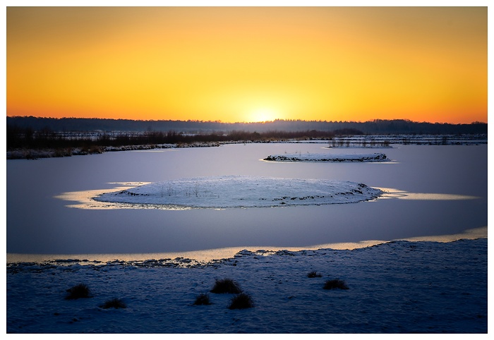 Roter Wintersonnenuntergang im schneebedeckten Himmelmoor