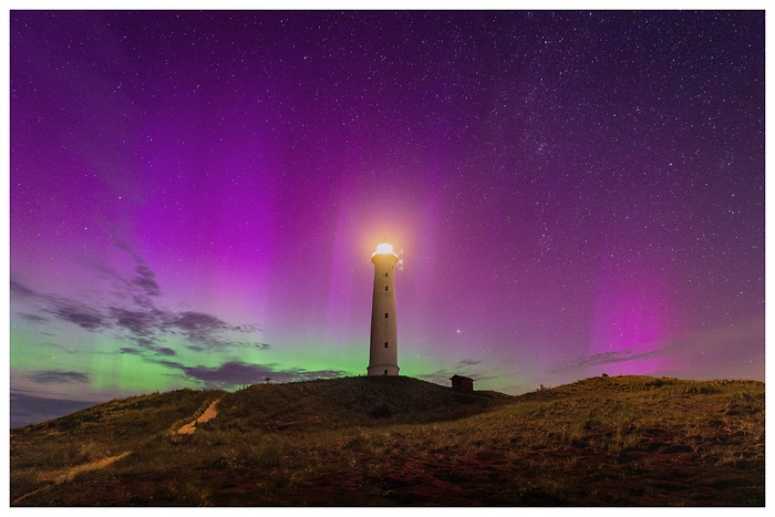 Blick auf den wunderschönen Nachthimmel mit Polarlichtern über dem Leuchtturm