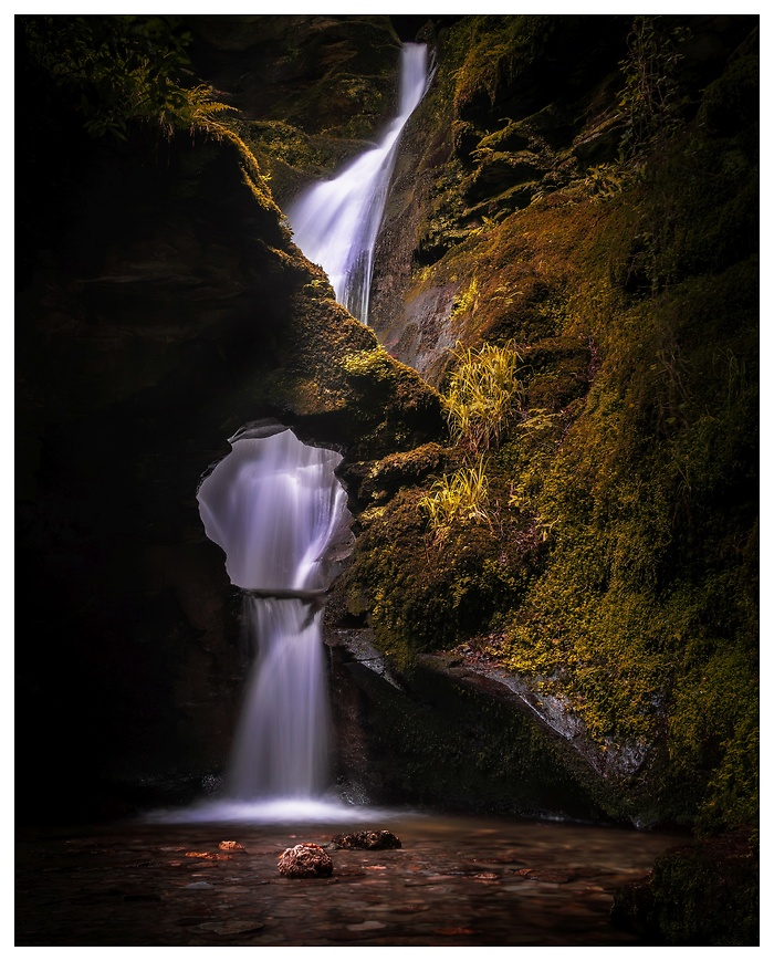 Blick auf einen beeindruckenden Wasserfall zwischen großen Felssteinen